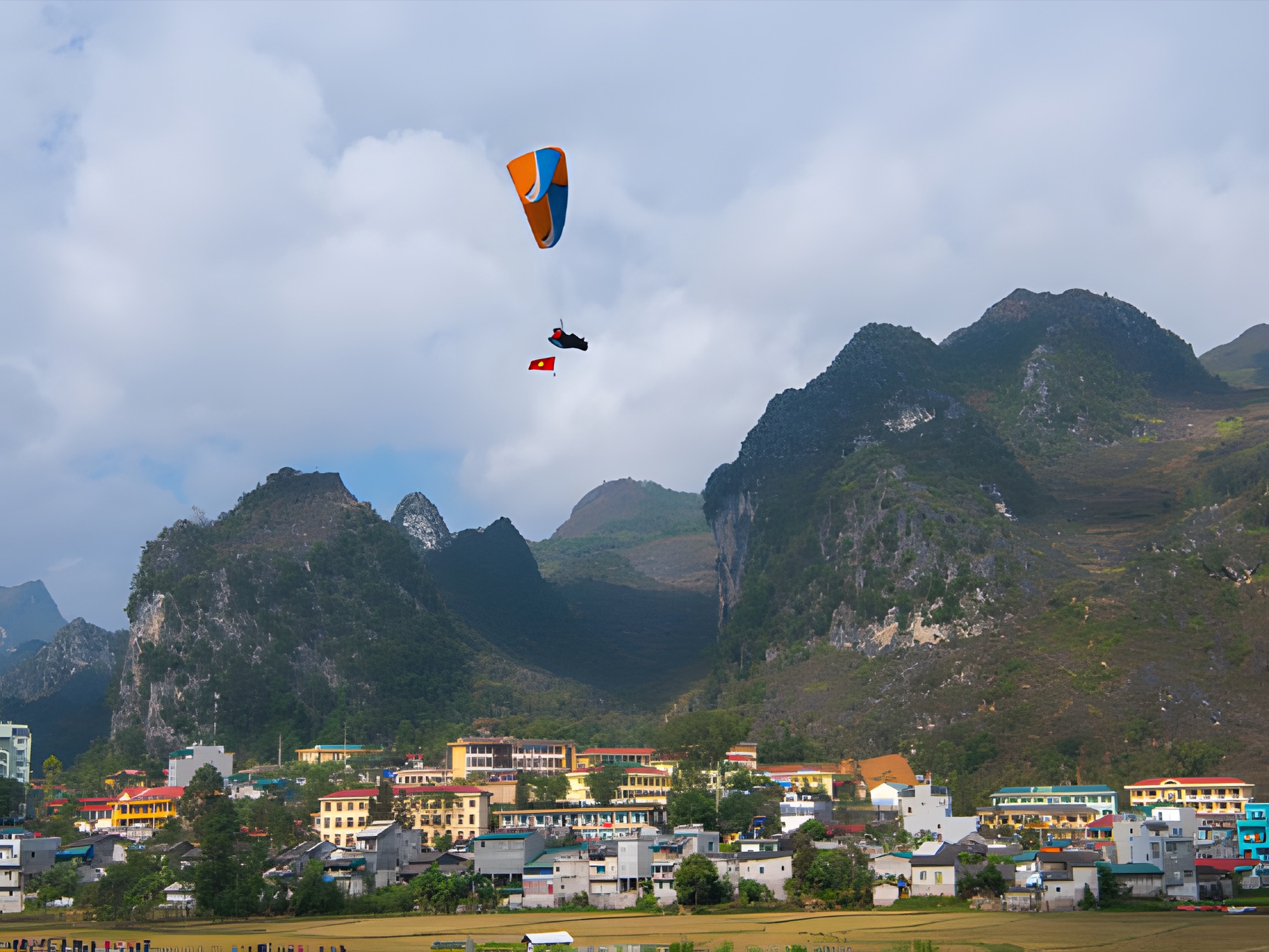 Phi công dù lượn mang cờ đỏ sao vàng trên cao nguyên đá Đồng Văn