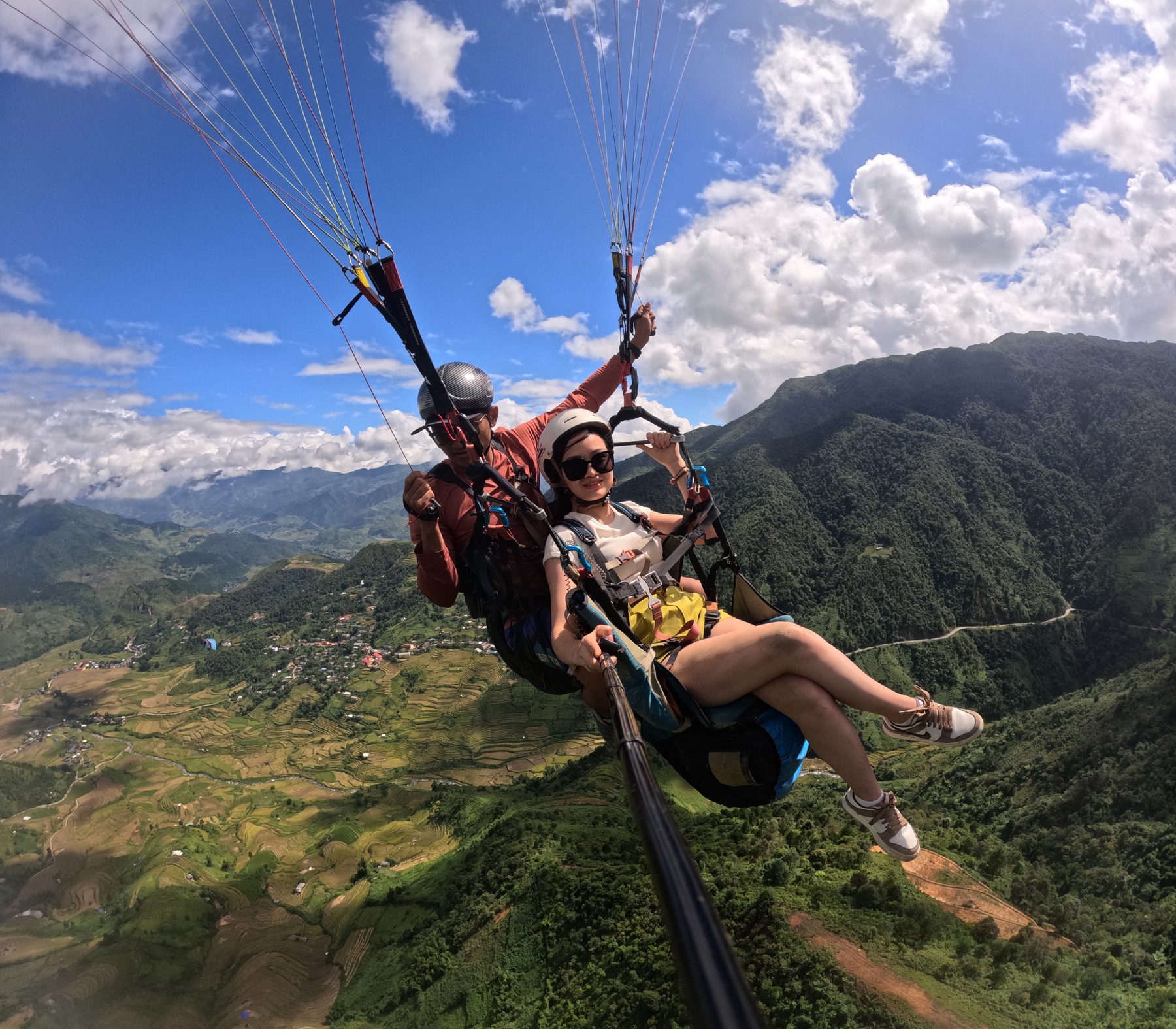 滑翔伞双人飞行，飞行员带客人飞越山谷