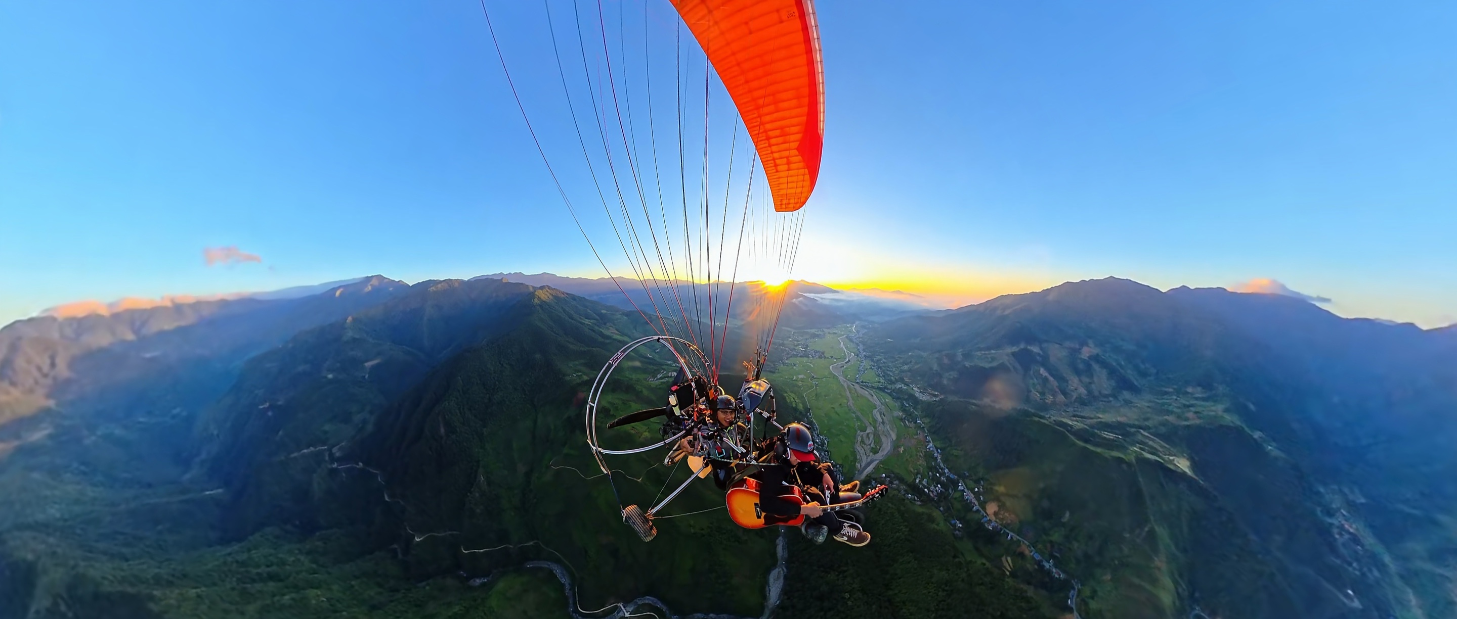 Bay paramotor đôi lúc hoàng hôn trên thung lũng